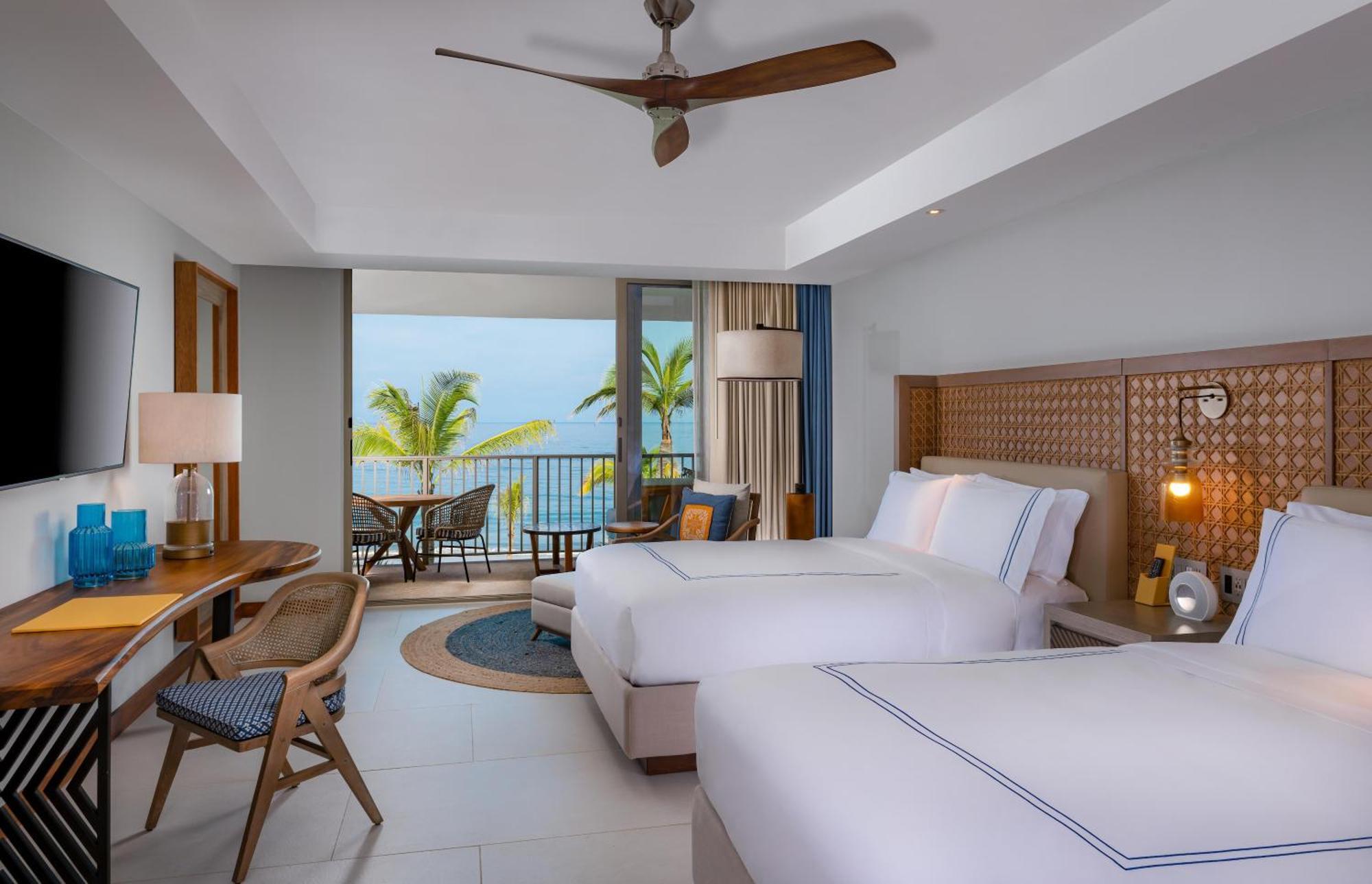 Habitación con 1 cama extragrande, 2 camas grandes y piscina pequeña frente al mar